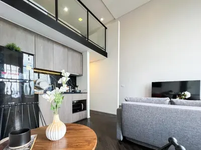 a living room with a couch and a table at Elegant 1BR Condo - Ultra Fast WiFi - BTS On-Nut in Bangkok