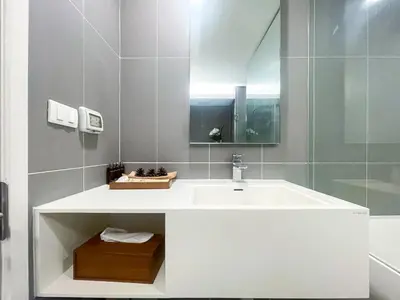 a white bathroom with a sink and a mirror at Elegant 1BR Condo - Ultra Fast WiFi - BTS On-Nut in Bangkok