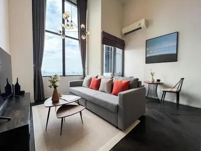a living room with a couch and a large window at Elegant 1BR Condo - Ultra Fast WiFi - BTS On-Nut in Bangkok