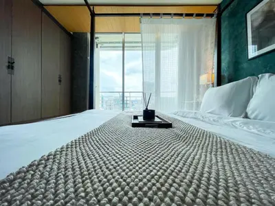 a bedroom with a large bed with a large window at Loft style Large 69 SQMFast WiFi BTS Chong Nonsi in Bangkok
