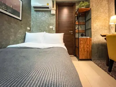 a bedroom with a bed and a table and a desk at Loft style Large 69 SQMFast WiFi BTS Chong Nonsi in Bangkok