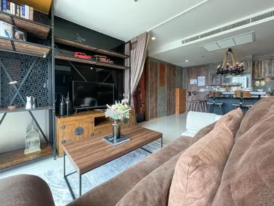 a living room with a couch and a television at Loft style Large 69 SQMFast WiFi BTS Chong Nonsi in Bangkok