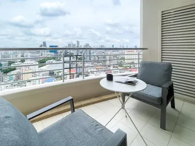 a balcony with a table and chairs and a view of a city at Spacious City 118 SQM Fast WiFi BTS Chong Nonsi in Bangkok