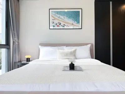 a white bed with a tray on top of it at Expansive Luxury 2BR - Ultra Fast Wifi - Phrom Phong in Bangkok