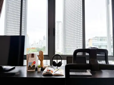 an office desk with a computer and books on it at Expansive Luxury 2BR - Ultra Fast Wifi - Phrom Phong in Bangkok