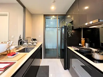 a kitchen with black cabinets and a counter top at Modern elegance 2B Ultra Fast WiFi BTS Phrakhanong in Bangkok