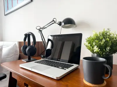 a laptop computer sitting on top of a wooden desk at Cozy Park-view 1BR - Ultra Fast Wifi - BTS Bangna in Bangkok