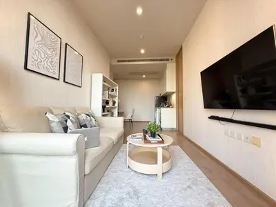 a living room with a white couch and a table at Luxurious Downtown 1BR - Ultra Fast WiFi - BTS Asoke in Bangkok