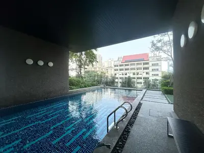 a swimming pool with a bench next to a building at Luxurious Downtown 1BR - Ultra Fast WiFi - BTS Asoke in Bangkok