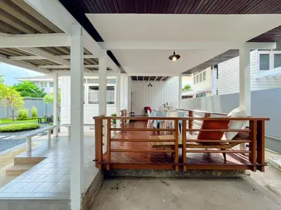 an open patio with a wooden bench on a deck at Entire House 3BR - White and Green Guesthouse in Bangkok Yai
