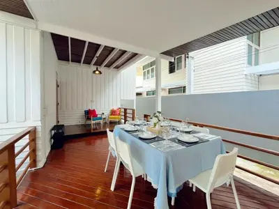 a dining room with a table and white chairs at Entire House 3BR - White and Green Guesthouse in Bangkok Yai