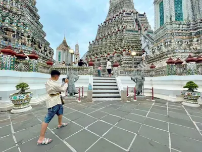 a man standing in front of a temple at Entire House 3BR - White and Green Guesthouse in Bangkok Yai