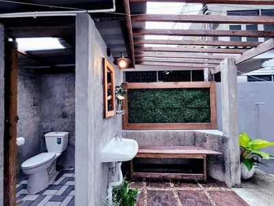 a bathroom with a toilet and a sink at Entire House 3BR - White and Green Guesthouse in Bangkok Yai