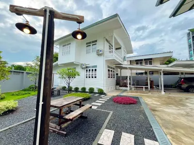 a house with a picnic table in front of it at Entire House 3BR - White and Green Guesthouse in Bangkok Yai
