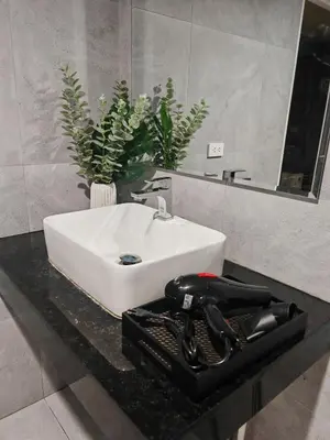 a bathroom sink with a hair dryer on a counter at Super cozy new townhome in central of Bangkok 4 PAX in Ban Chek
