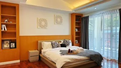 a bedroom with a bed and a large window at Bangkok Manor Two\u66fc\u8c37\u8d30\u53f7\u5e84\u56ed in Bangkok