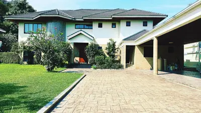 a large white house with a brick driveway at Bangkok Manor Two\u66fc\u8c37\u8d30\u53f7\u5e84\u56ed in Bangkok