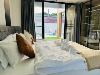 a bed with white sheets and pillows in a bedroom at Bangkok Manor Two\u66fc\u8c37\u8d30\u53f7\u5e84\u56ed in Bangkok