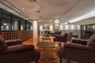 a waiting room with couches and chairs and a table at Hotel Once Bangkok in Bangkok