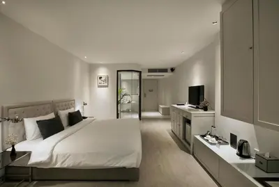 a bedroom with a large white bed and a television at Hotel Once Bangkok in Bangkok