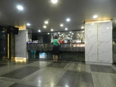 a woman standing at a bar in a restaurant at Nanatai Suites in Bangkok
