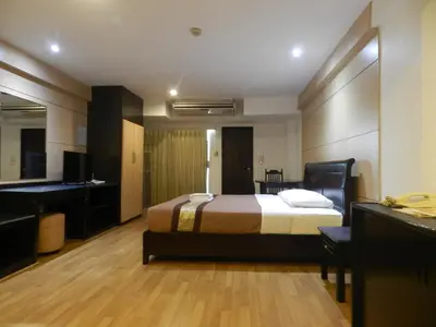 a hotel room with a bed and a bathroom at Nanatai Suites in Bangkok