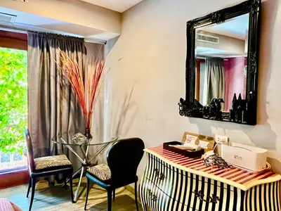 a room with a mirror and a desk and chairs at WiNNiNE Cozy Home in Bangkok