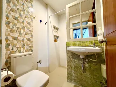 a small bathroom with a toilet and a sink at WiNNiNE Cozy Home in Bangkok