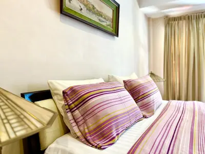 a bedroom with a bed with two pillows on it at WiNNiNE Cozy Home in Bangkok