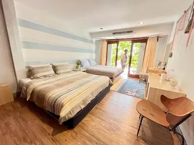 a bedroom with a large bed and a couch at WiNNiNE Cozy Home in Bangkok