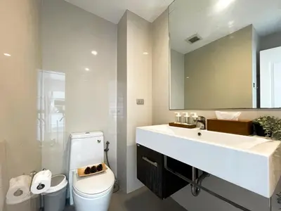 a bathroom with a sink and a toilet and a mirror at Prime Sukhumvit Stay 1 BR - Fast WiFi - BTS Udomsuk in Bangkok
