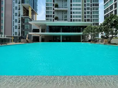 a large blue swimming pool in front of buildings at Prime Sukhumvit Stay 1 BR - Fast WiFi - BTS Udomsuk in Bangkok