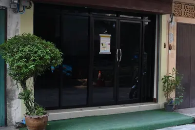 a door of a building with a potted tree in front at Chaiwat Guesthouse in Bangkok