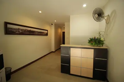a room with a counter and a fan on the wall at Chaiwat Guesthouse in Bangkok