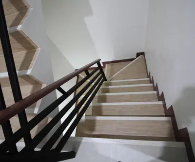 a staircase with wooden railings in a house at Chaiwat Guesthouse in Bangkok