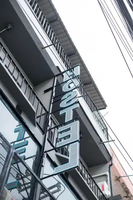 a sign hanging from the side of a building at Another High Away Hostel - Bangkok in Nonthaburi