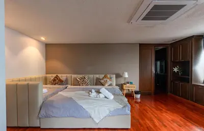 a bedroom with a large bed with two cats laying on it at Thonglor 25 Noble House in Bangkok