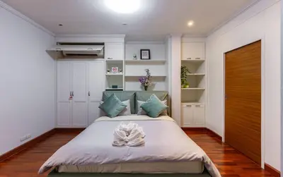a bedroom with a large bed with blue pillows at Thonglor 25 Noble House in Bangkok
