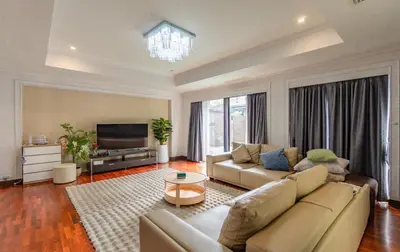a living room with a couch and a television at Thonglor 25 Noble House in Bangkok