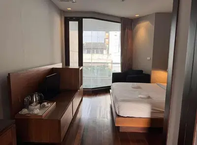 a hotel room with a bed and a window at XX Wish Inn Silom Bangkok - วิชอินน์ สีลม กรุงเทพ in Bangkok