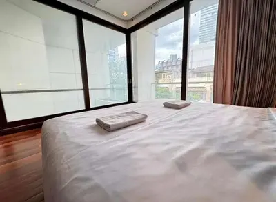 a bedroom with a large bed with two towels on it at XX Wish Inn Silom Bangkok - วิชอินน์ สีลม กรุงเทพ in Bangkok