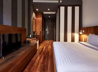 a bedroom with a bed and a flat screen tv at XX Wish Inn Silom Bangkok - วิชอินน์ สีลม กรุงเทพ in Bangkok