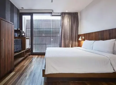 a bedroom with a large bed and a large window at XX Wish Inn Silom Bangkok - วิชอินน์ สีลม กรุงเทพ in Bangkok
