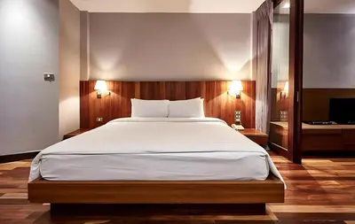 a bedroom with a large bed and a television at XX Wish Inn Silom Decho Road - วิช อินน์ สีลม เดโช in Bangkok
