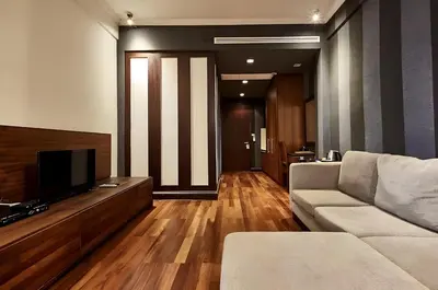 a living room with a couch and a flat screen tv at XX Wish Inn Silom Decho Road - วิช อินน์ สีลม เดโช in Bangkok