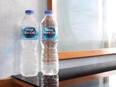 two bottles of water are sitting on a shelf at XX Wish Inn Chidlom Bangkok - วิชอินน์ ชิดลม กรุงเทพ in Pratunam