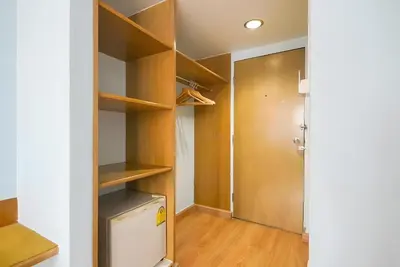 a closet with wooden shelves and a refrigerator at XX Wish Inn Chidlom V - วิชช์อินน์ ชิดลม in Pratunam
