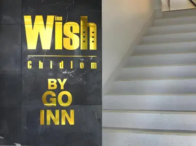 a staircase with a yellow sign on the wall at XX Wish Inn Chidlom V - วิชช์อินน์ ชิดลม in Pratunam