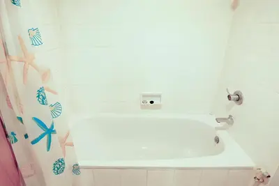 a bathroom with a shower with a white tub at XX Wish Inn Chidlom V - วิชช์อินน์ ชิดลม in Pratunam