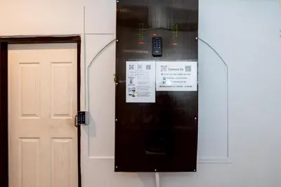 a door to a room with a cell phone on the wall at xx The Hidden Khaosan Road เดอะ ฮิดเด้น ถนนข้าวสาร - รามบุตรี in Bang Bua Thong Railway Station